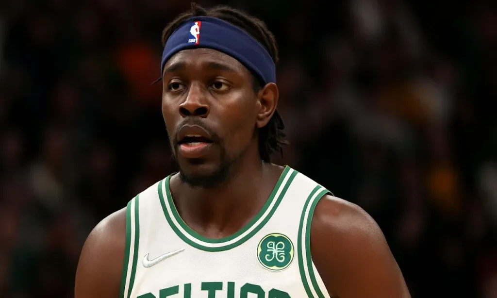 A clear image of Jrue Holiday wearing his Boston Celtics jersey and a headband, with an intense expression during the NBA Offseason.